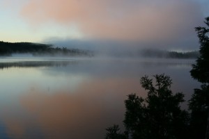 Lake with pink sky and mist