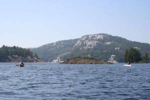 Paddling down a lake toward white rock hills.