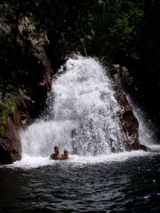 two people at the base of a waterfall