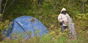 Blue tent and man wearing a bug jacket.