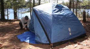 Man setting up a blue tent.