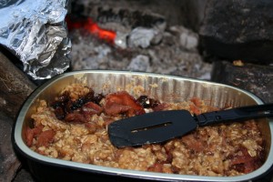 Fruit crisp with campfire in the background