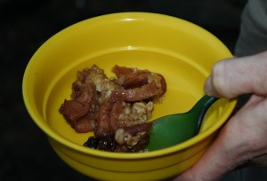 Yellow bowl, green spoon, a hand and some crisp.