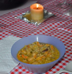 Blue bowl of stew on red checked table cloth