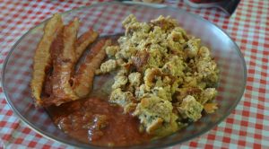 Plate with casserole, bacon and chili sauce