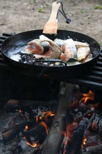 Fish cooking in pan on a open fire