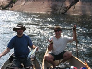 two canoes, two men consulting a map.