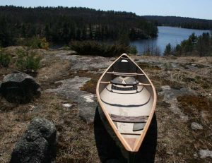 a canoe at the top of a hill with a view of the lake