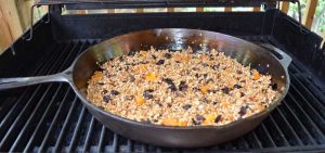 granola in a cast iron pan on the barbecue