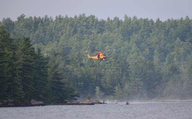 Helicopter leaving a campsite on the lake.