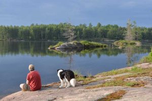 Woman and dog on shore with black clouds