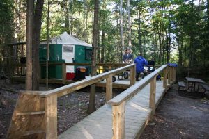 green yurt with wood walkway