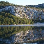 White rocks, green trees reflected in water