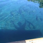 Paddler reflected in blue water