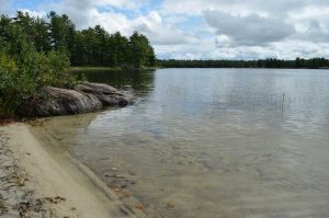 beach, rock, water and blue sky with clouds