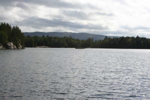 gray sky with hills in the distance over water