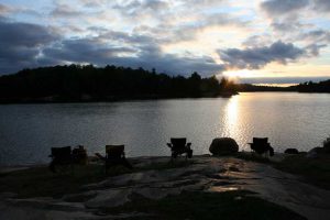 chairs on shore with sunset