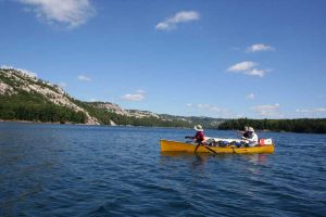 two canoes, blue sky, blue water and white rocks