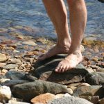 man barefoot on rocks