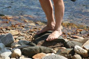 man barefoot on rocks