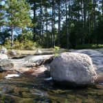 campsite from the water, large rock