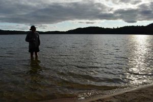 man standing in water in sunset