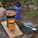 stove on a plank cooking bacon