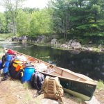 Packs next to a green canoe