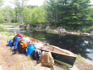 Packs next to a green canoe