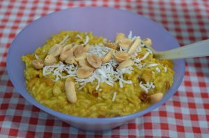 Curry and rice in a blue bowl with a red check table cloth