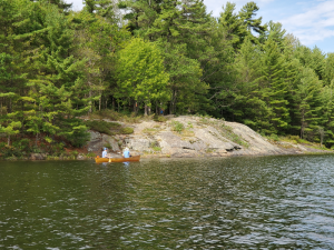 Canoe paddling past a rock campsite