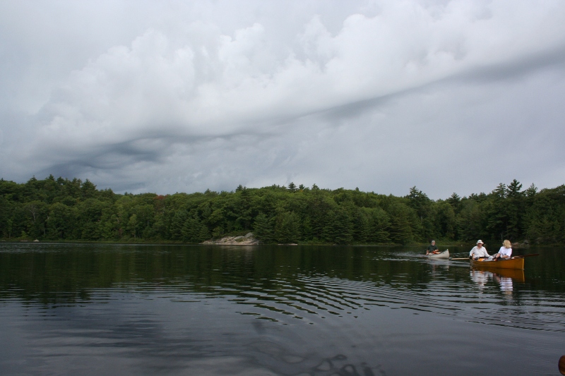 Canoe followed by storm cloud
