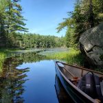 Canoe on shore of a pond